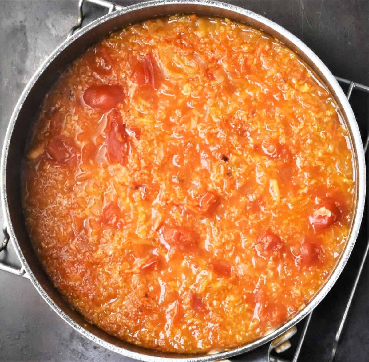 Cabbage soup with tomatoes in large pot.