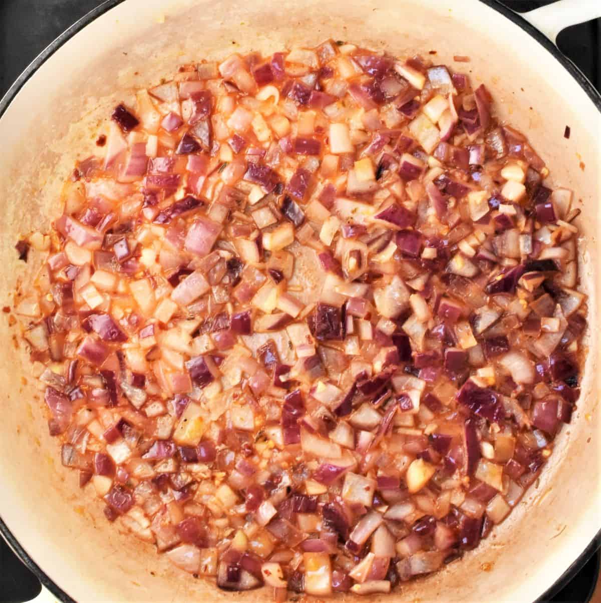 Chopped red onion in large shallow pan.