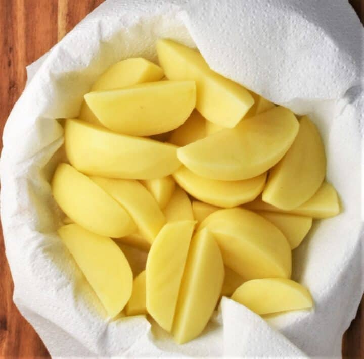 Top down view of potato wedges on top of paper towel.