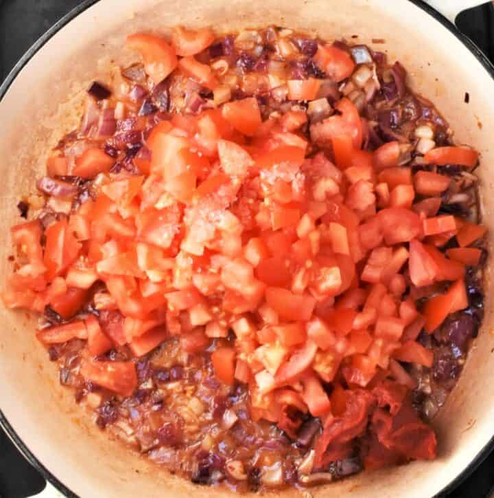 Onion and chopped tomatoes in shallow pan.