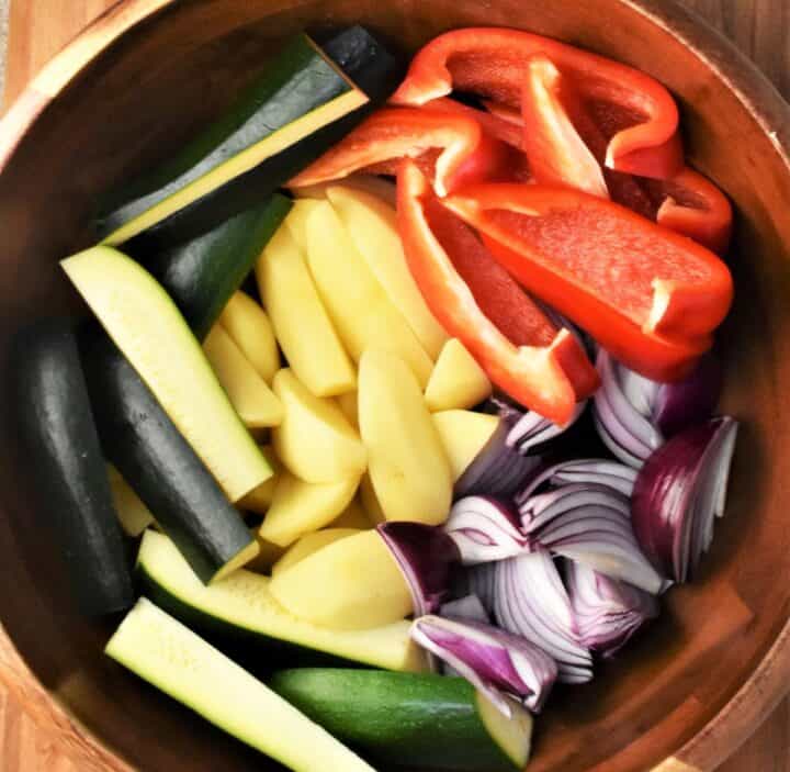 Vegetables cut into long strip in brown bowl.