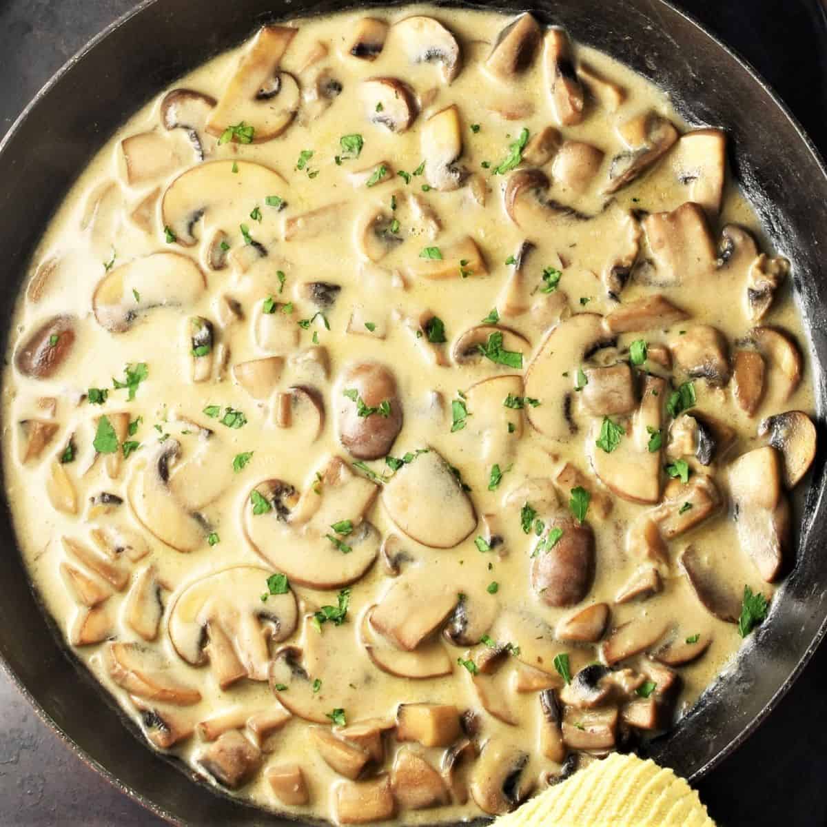 Top down view of mushroom sour cream sauce in large shallow pan.