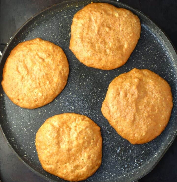 Top down view of cooking 4 pumpkin pancakes.