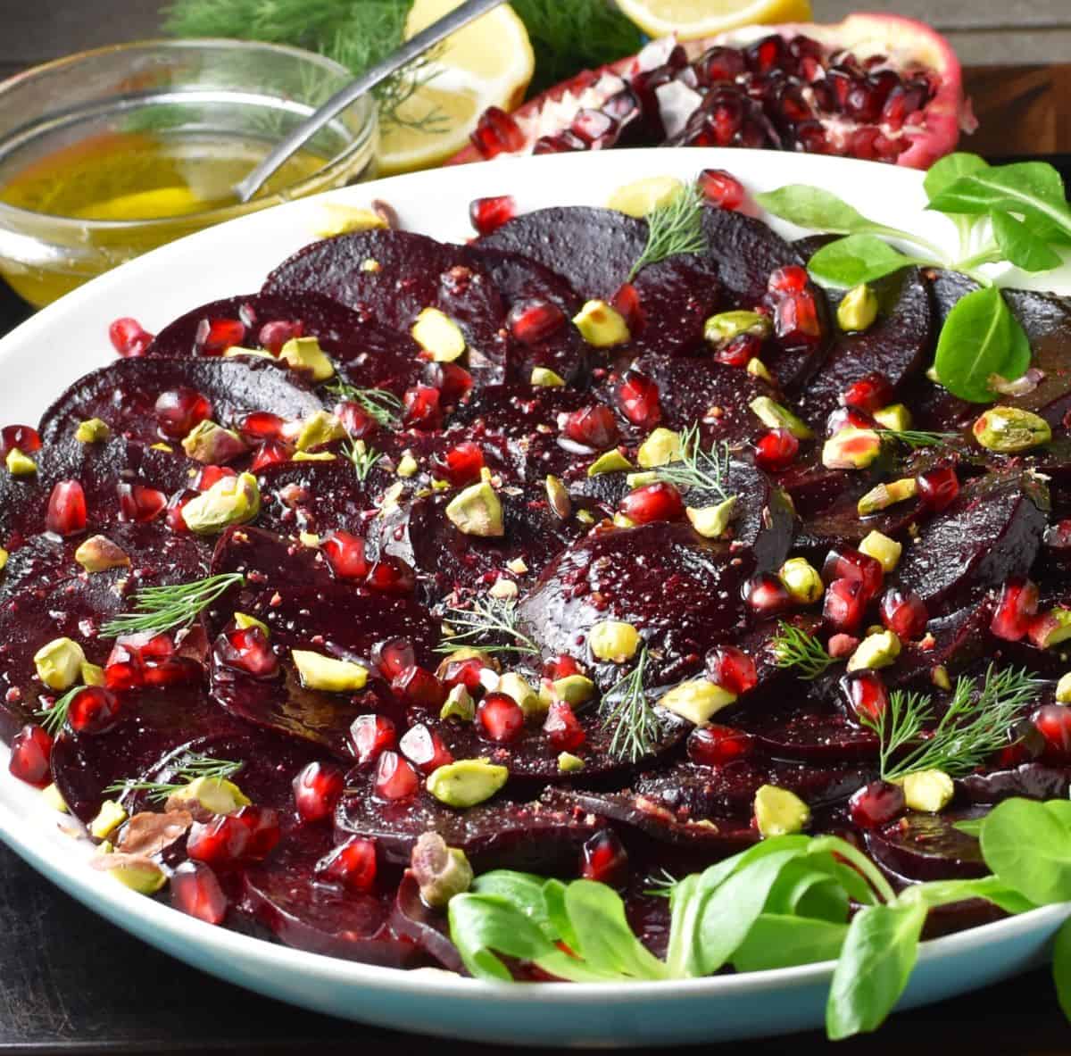 Side view of carpaccio with beets on white plate.