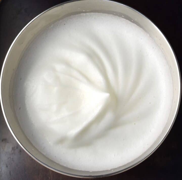 Fluffy egg white mixture in metal bowl.