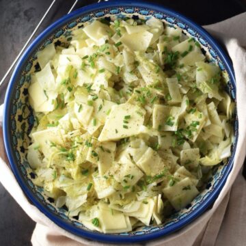 Top down view of cabbage pasta in blue bowl.