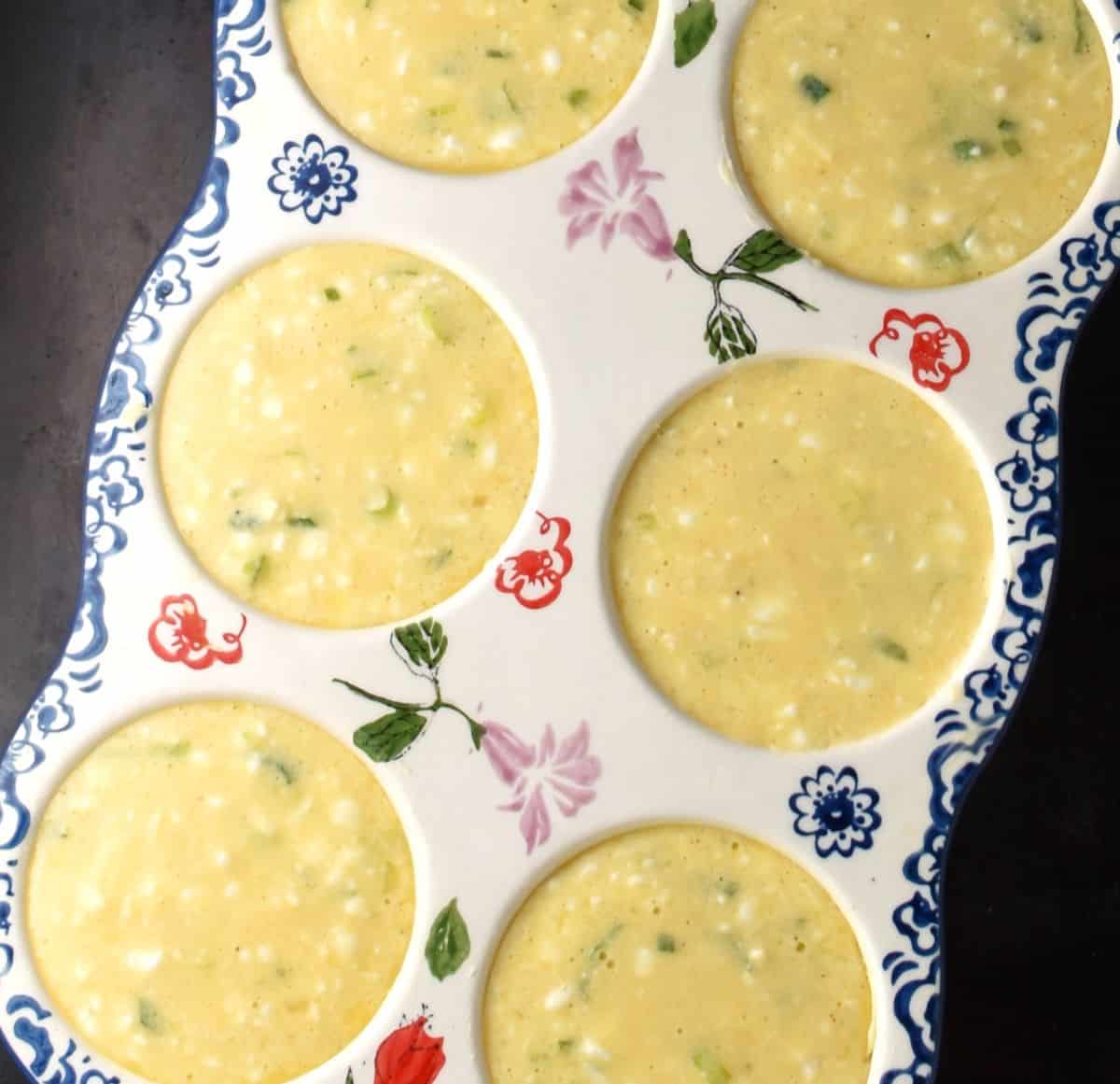 6-hole ceramic muffin pan filled with cottage cheese and egg muffin batter.