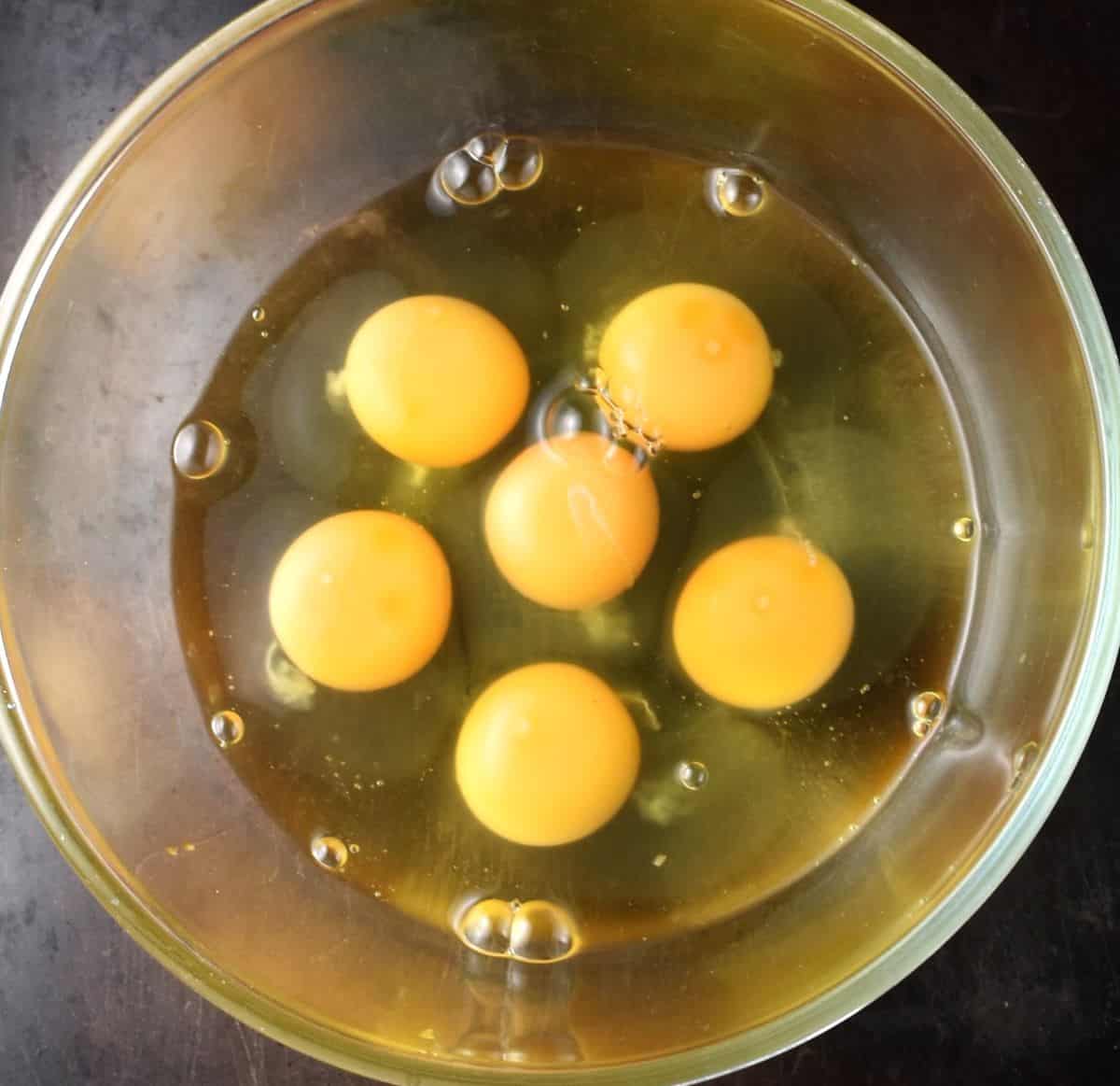 Top down view of 6 eggs in mixing bowl.