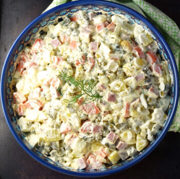 Top down view of Olivier salad in blue bowl.
