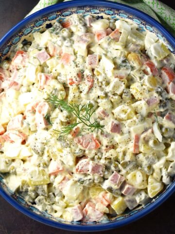 Top down view of Olivier salad in blue bowl.