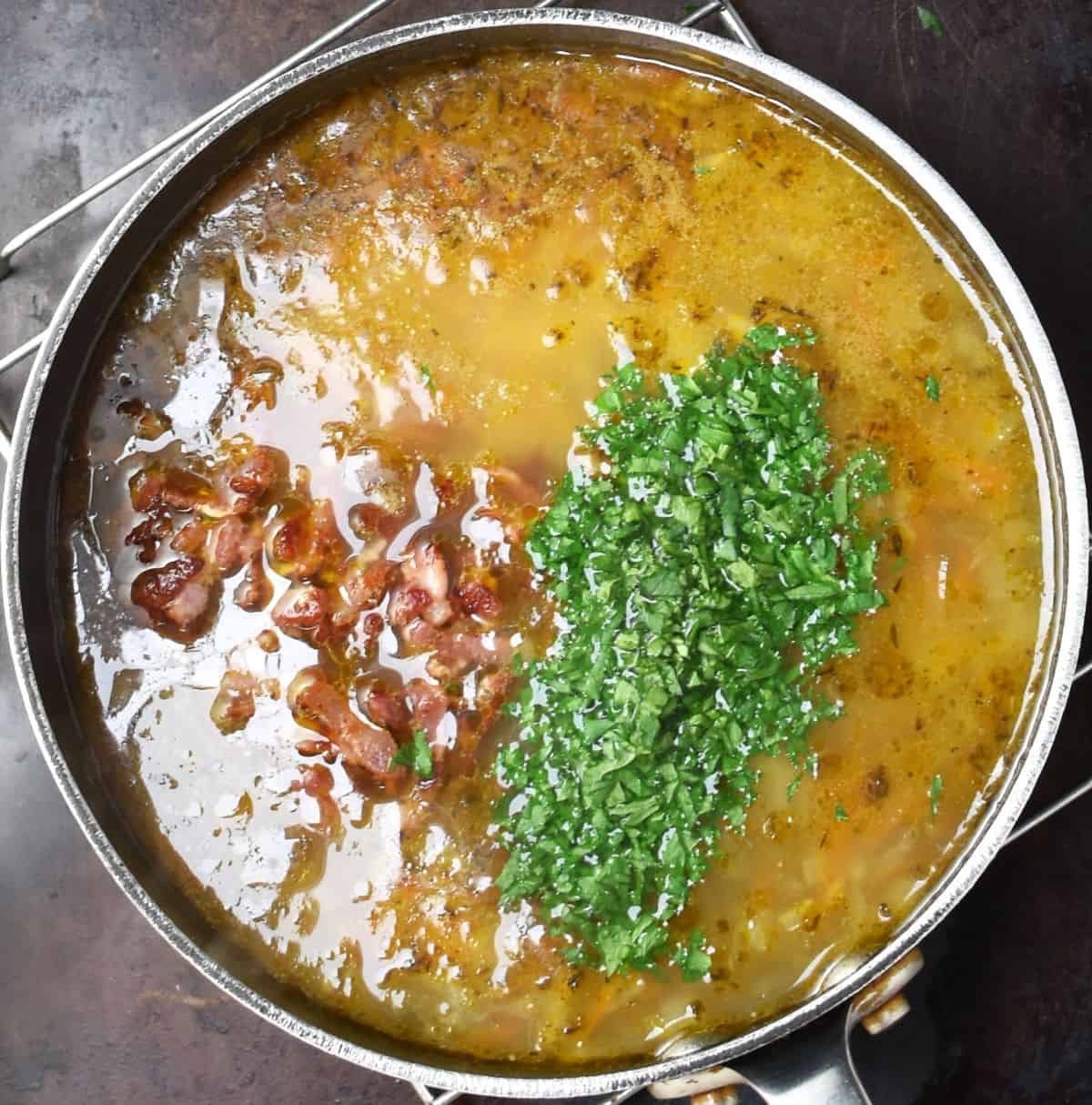 Potato soup with bacon and parsley in large pot.