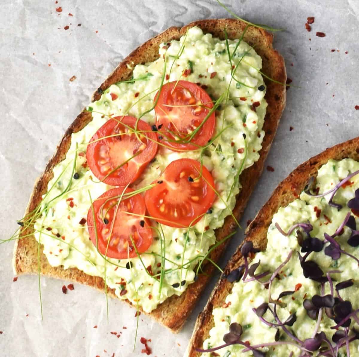 Top down view of cottage cheese avocado toasts with cherry tomatoes.
