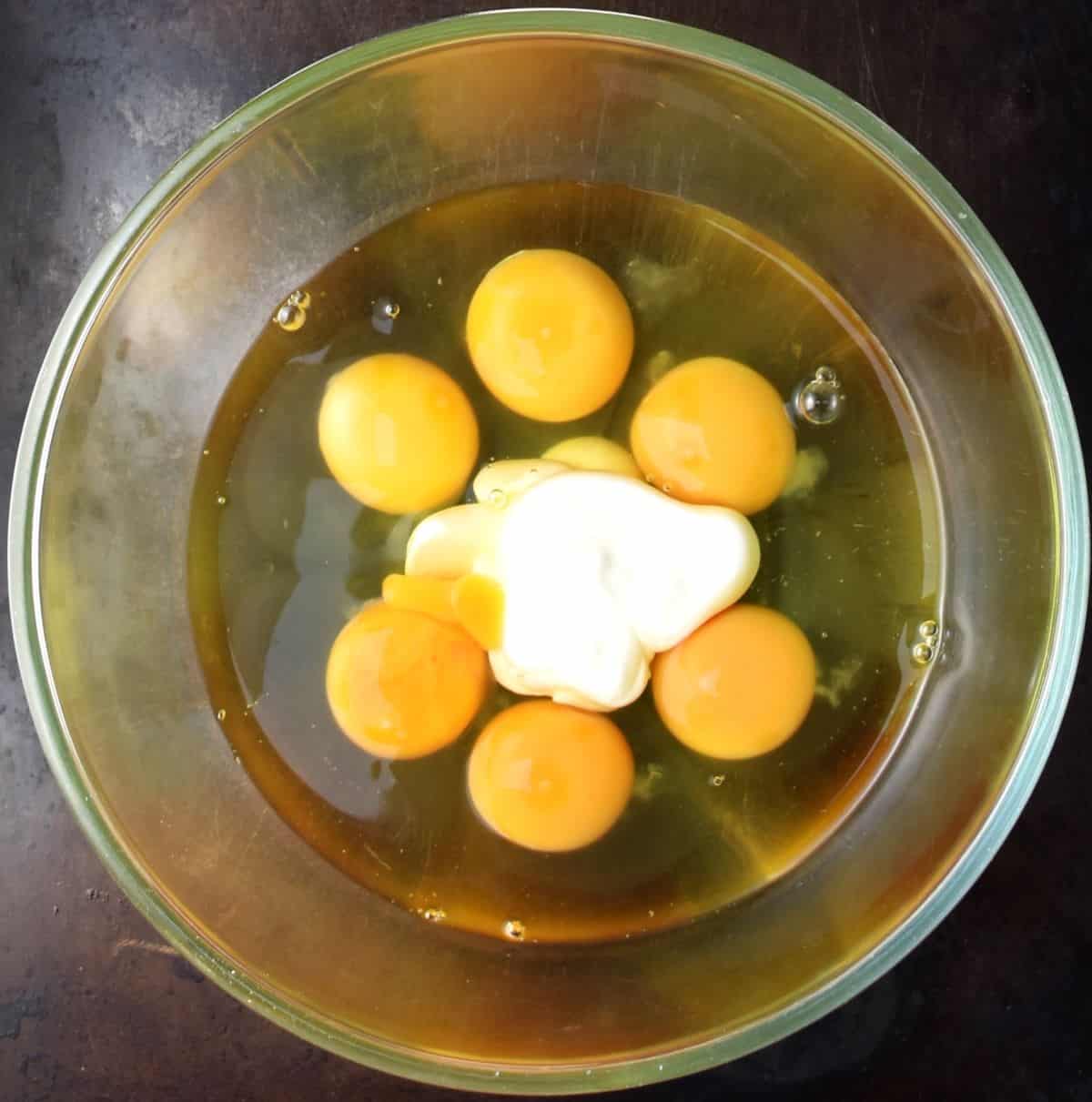 6 eggs and yogurt in glass bowl.