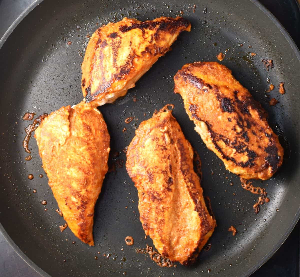 4 pieces of cooked yogurt chicken in large pan.