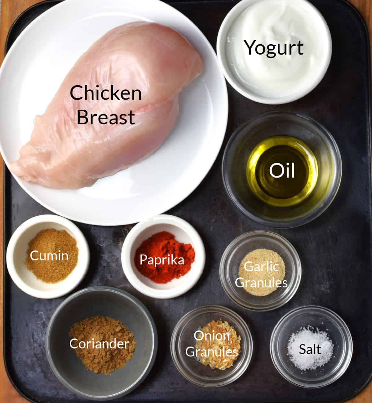 Ingredients for making yogurt marinated chicken breast in individual dishes.