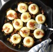 Top down view of silesian dumplings with bacon and onion in pan.