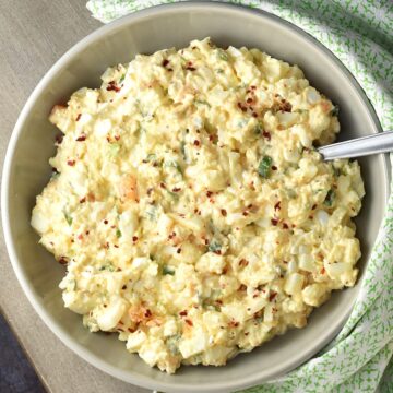 Top down view of cottage cheese egg salad in grey bowl with spoon.