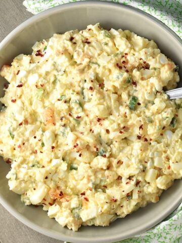 Top down view of cottage cheese egg salad in grey bowl with spoon.