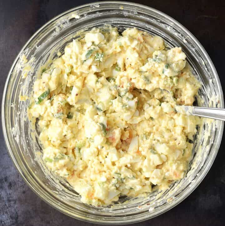 Assembled egg and cottage cheese salad in glass bowl with fork.