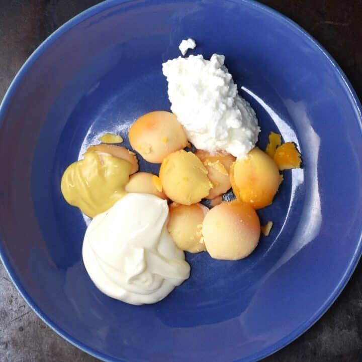 Egg yolks with cottage cheese and mayonnaise in blue bowl.