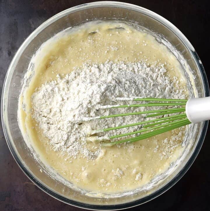 Combining wet and dry mixtures with whisk in glass bowl.