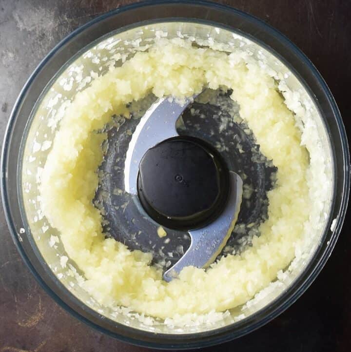 Top down view of pureed onion mixture in food processor.