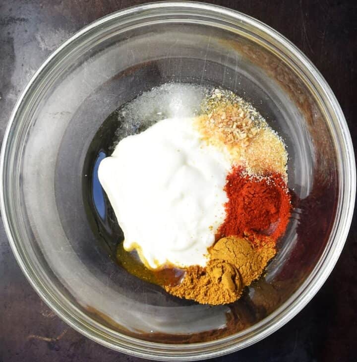 Top down view of yogurt and spices in glass bowl.