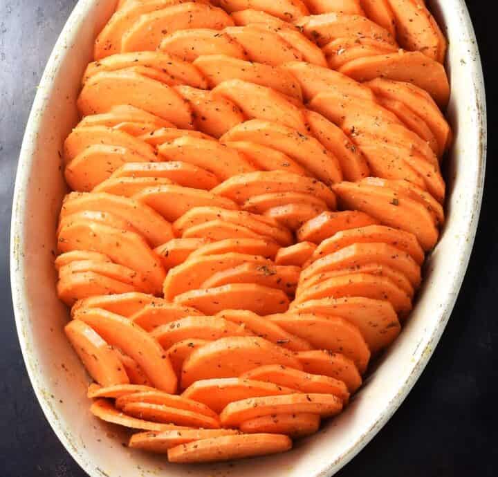 Sweet potato rounds arranged vertically in white oval dish.