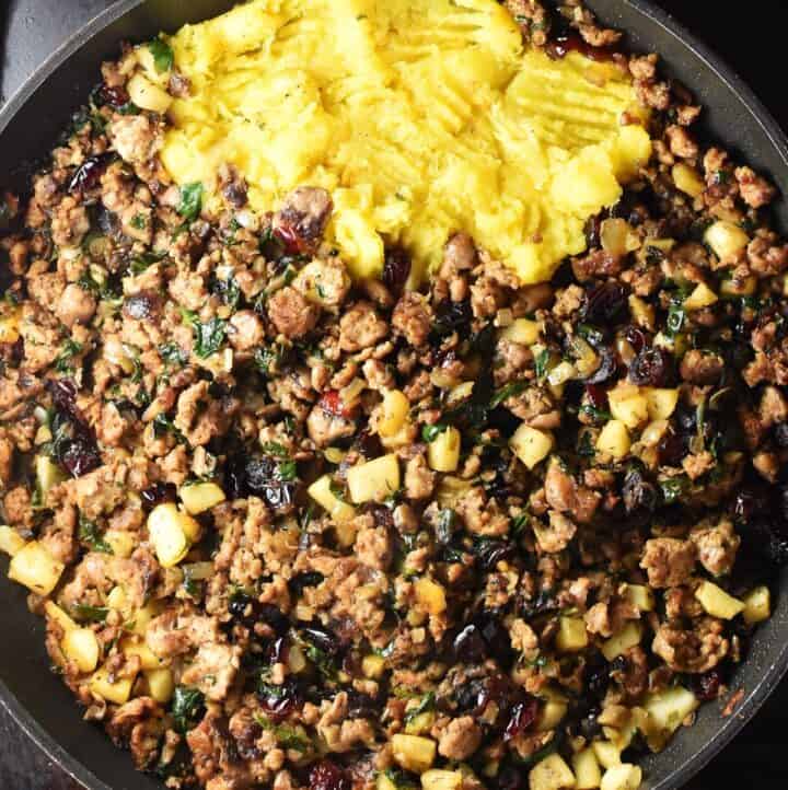 Sausage stuffing filling with mashed squash in large pan.
