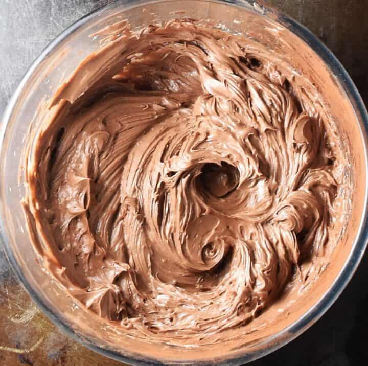 Creamy chocolate hazelnut frosting in glass bowl.