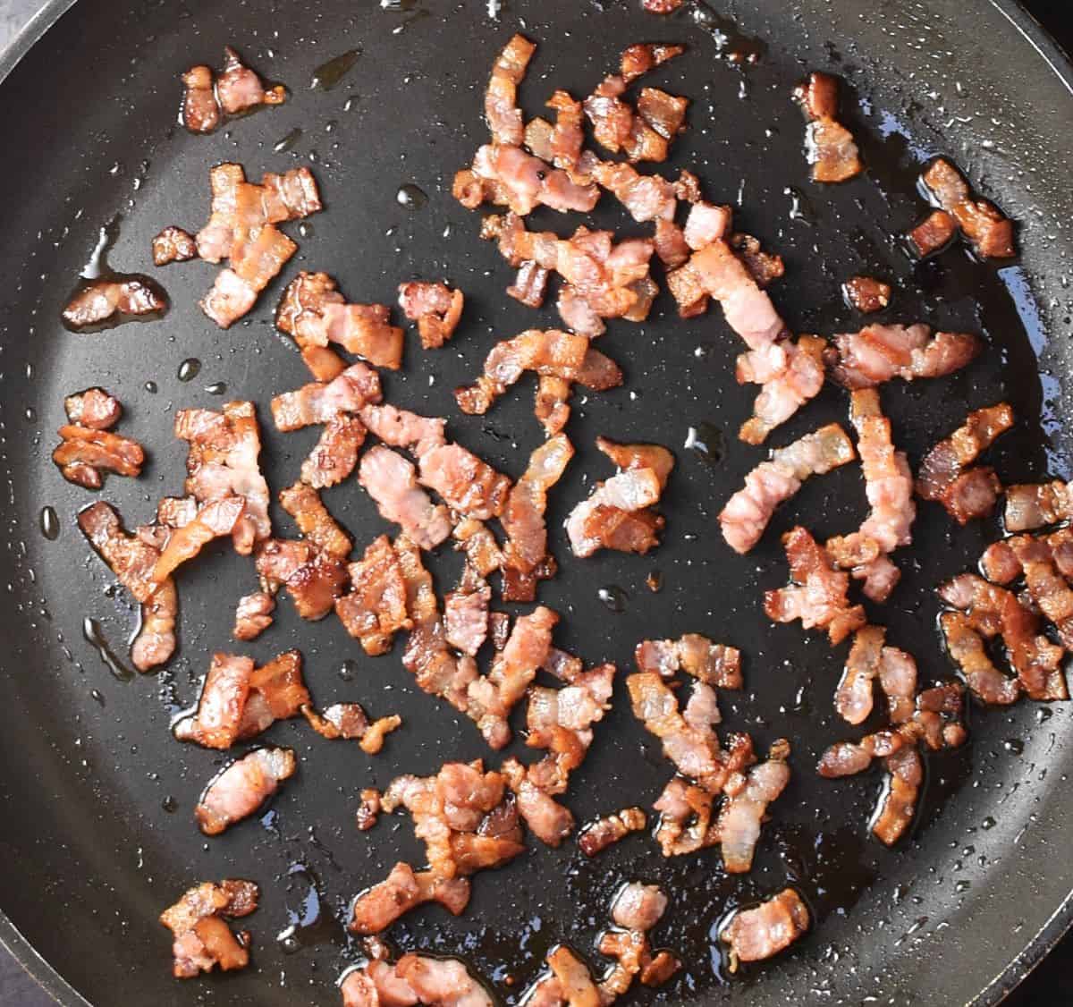 Top down view of crispy bacon in large pan.