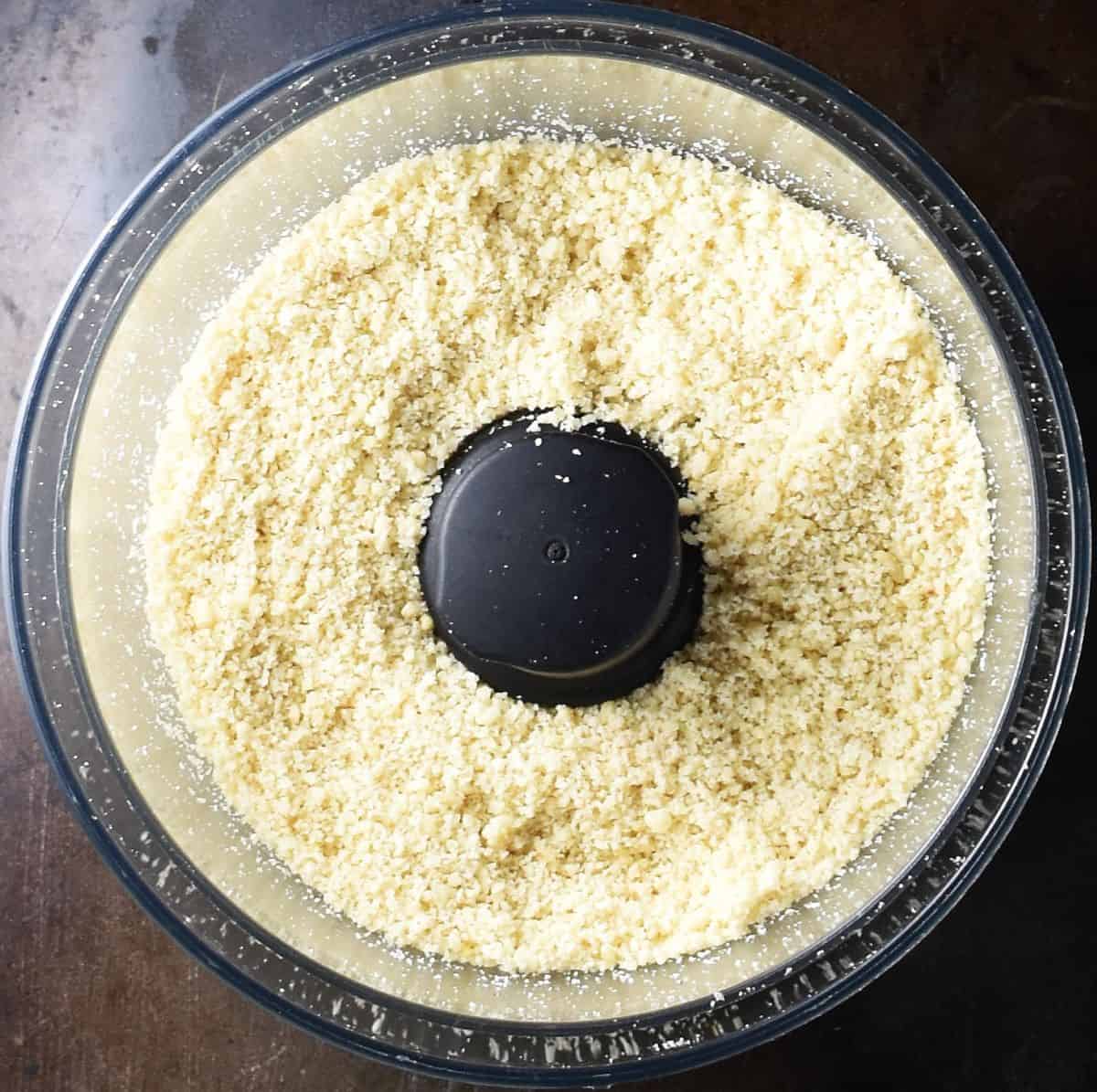 Ground hazelnuts in food processor bowl.