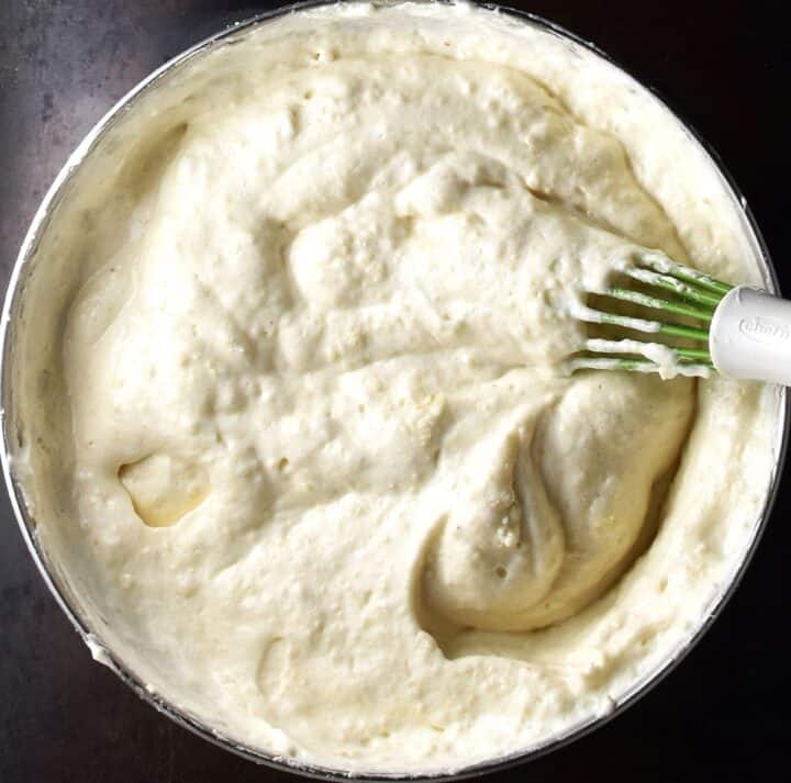 Creamy hazelnut torte batter in bowl with whisk.