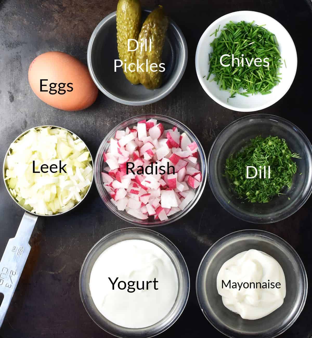Ingredients for making dill pickle egg salad in individual dishes.