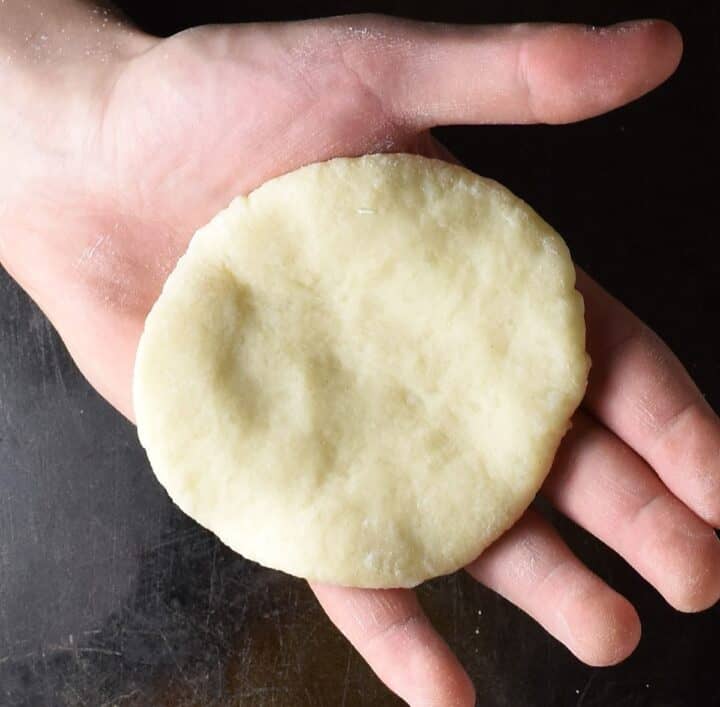 Round dough shape on top of a hand.