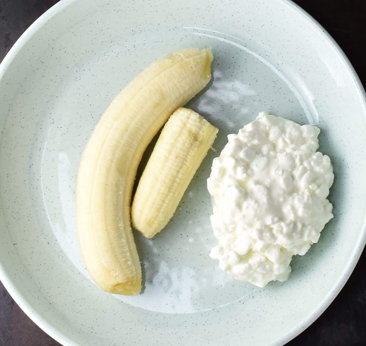 Peeled bananas and cottage cheese in blue bowl.