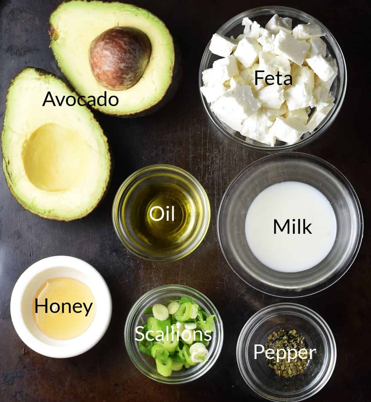 Ingredients for making avocado feta toast in individual dishes.