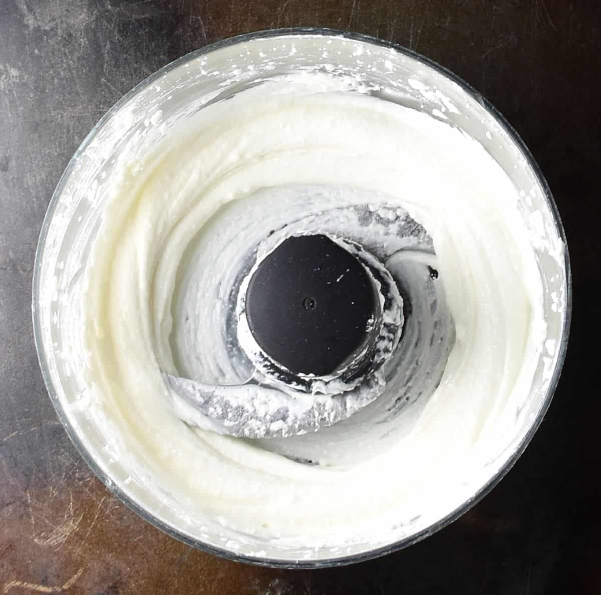 Creamy feta cheese mixture in food processor bowl.