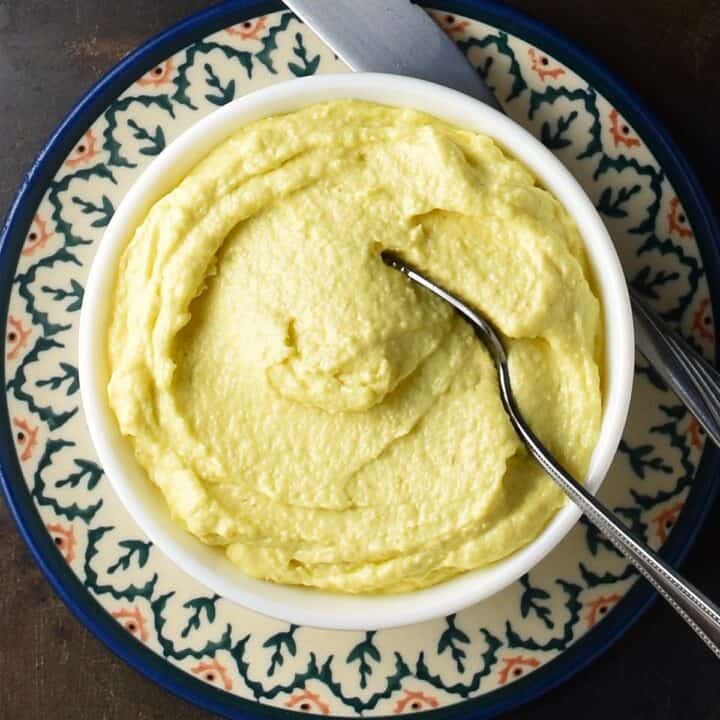 Top down view of creamy horseradish mayonnaise in white bowl with spoon.