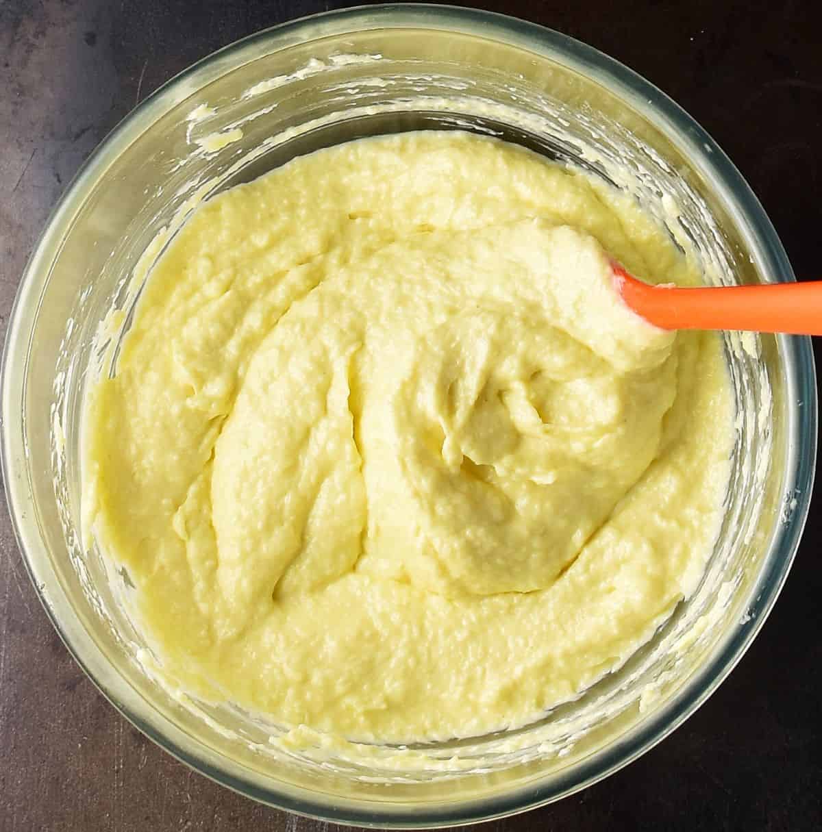 Creamy horseradish mayonnaise in glass bowl with orange spoon.