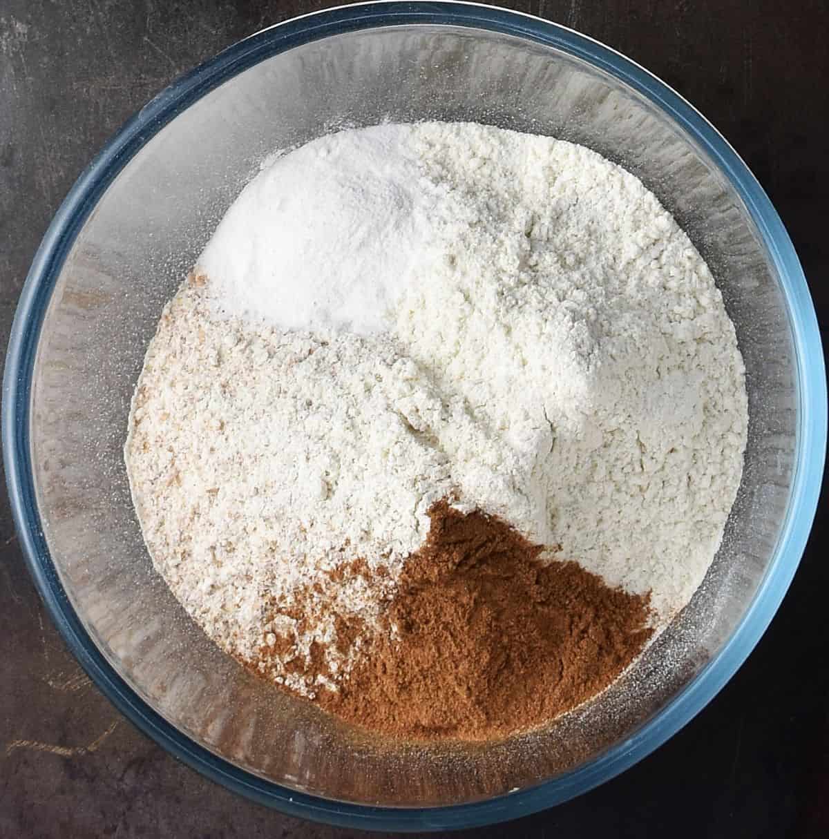 Top down view of dry mixture for banana and cottage cheese muffins in glass bowl.