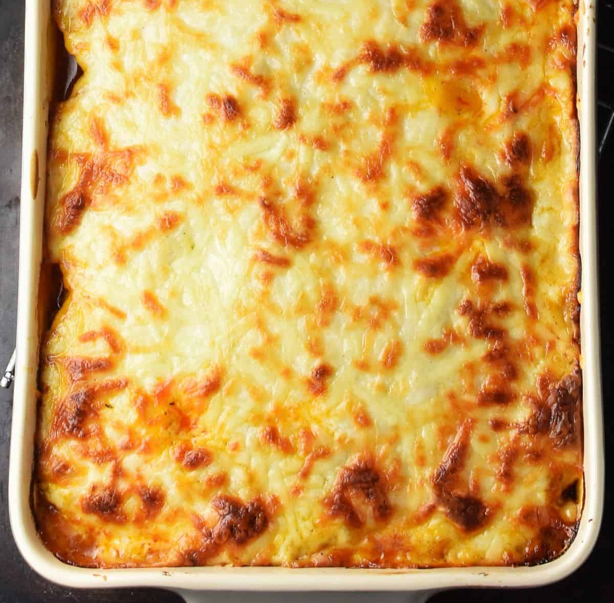Top down view of baked potato meat lasagna in rectangular dish.