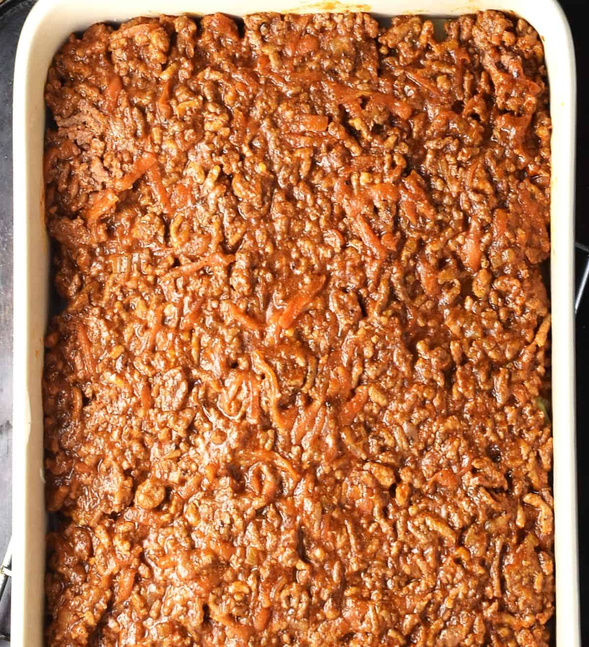 Meat filling mixture layer in rectangular lasagna dish.