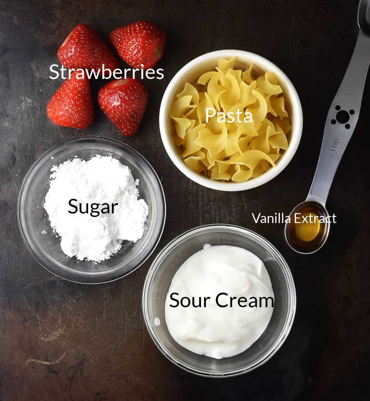 Top down view of strawberry pasta ingredients in individual dishes.