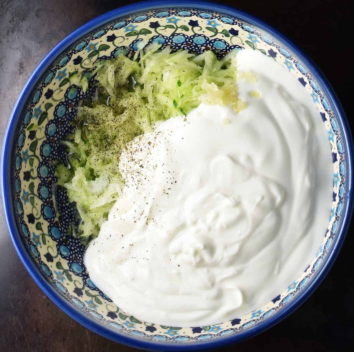 Grated cucumber and kefir in blue bowl.