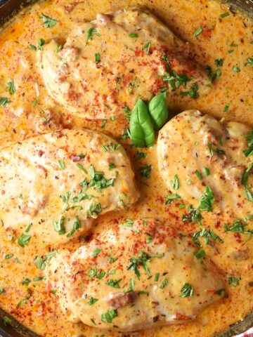 Top down close-up view of 4 healthy marry me chicken breasts in creamy sauce in pan.