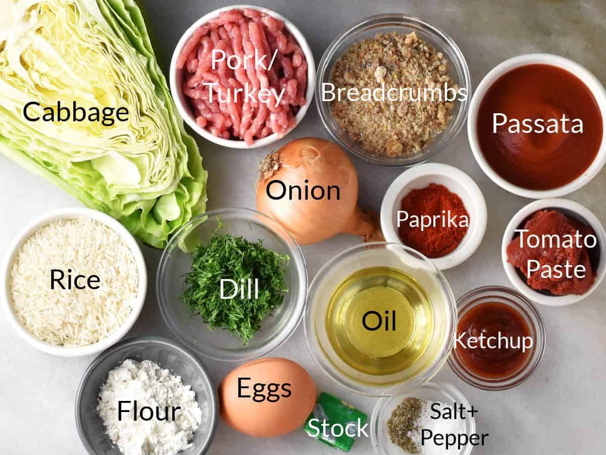 Polish unstuffed cabbage rolls ingredients in individual dishes on marble top.