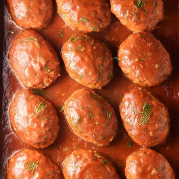 Top down view of Polish unstuffed cabbage rolls in tomato sauce with dill.