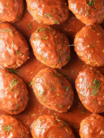 Top down view of Polish unstuffed cabbage rolls in tomato sauce with dill.