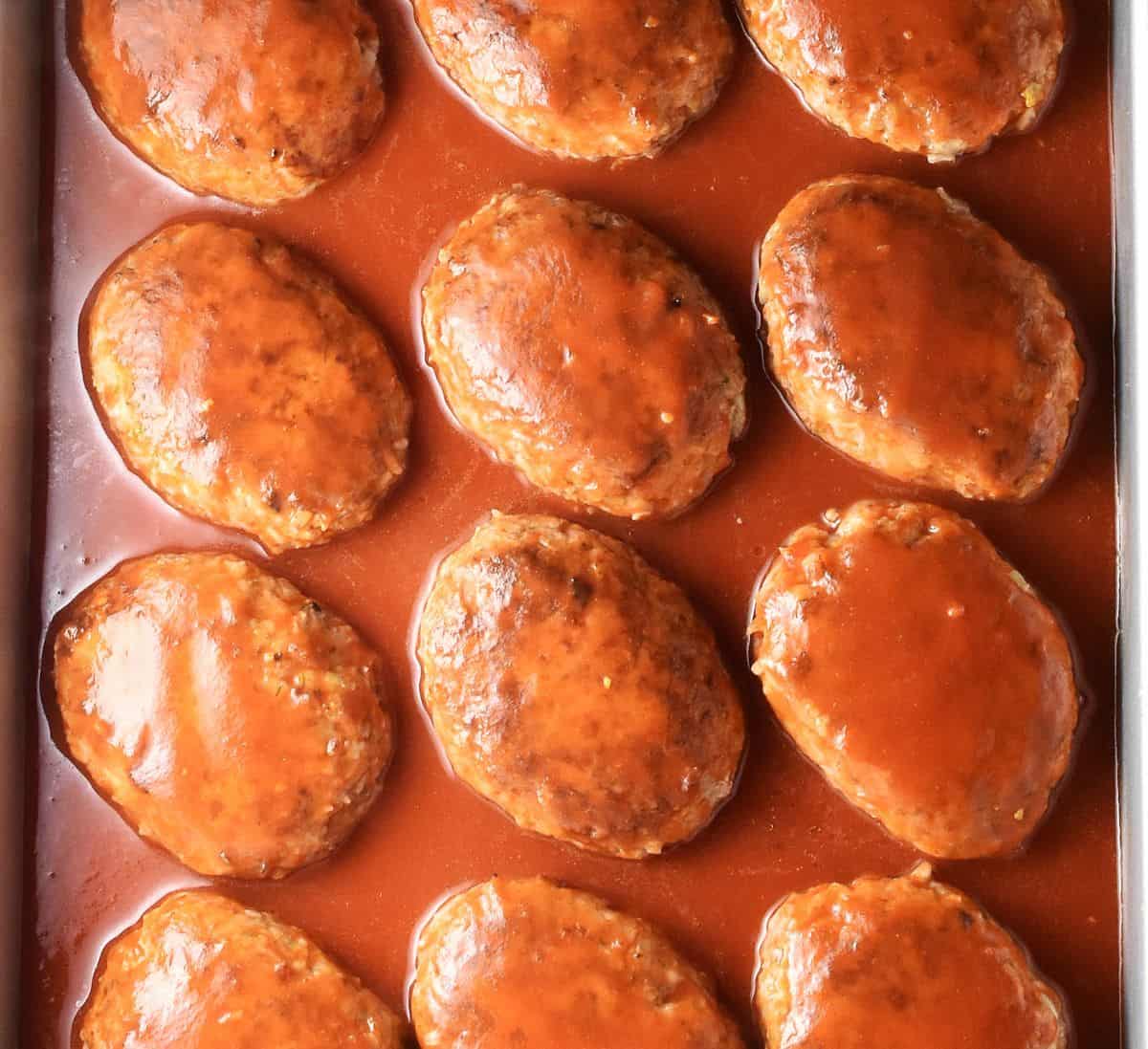 Uncooked lazy Polish cabbage rolls in tomato sauce in large pan.
